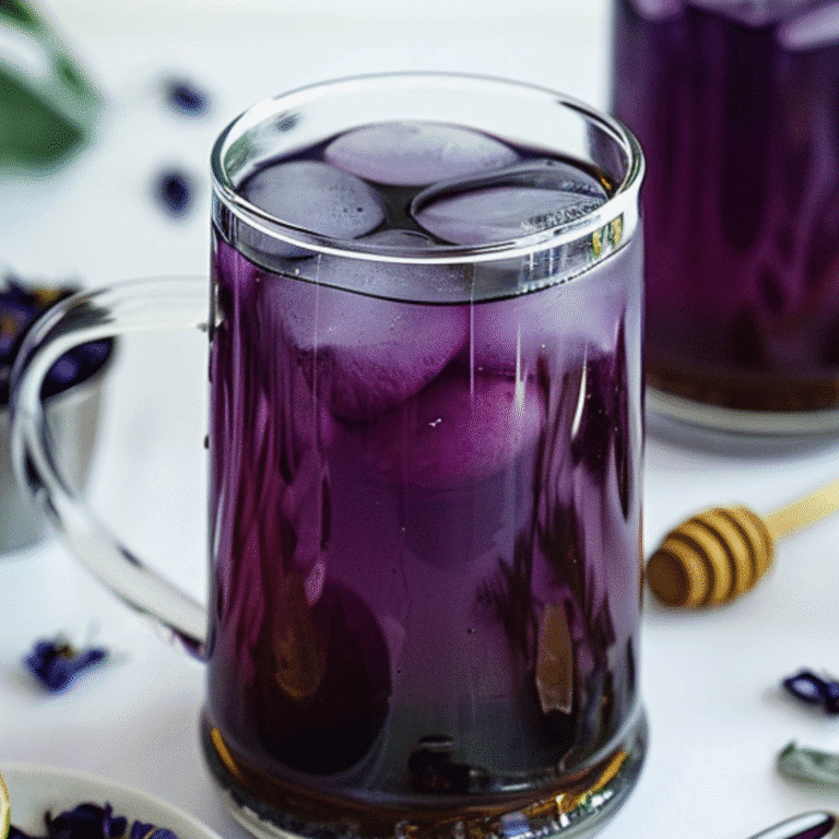 Butterfly Pea Flower Tea with lime, honey, and dried flowers on a white background