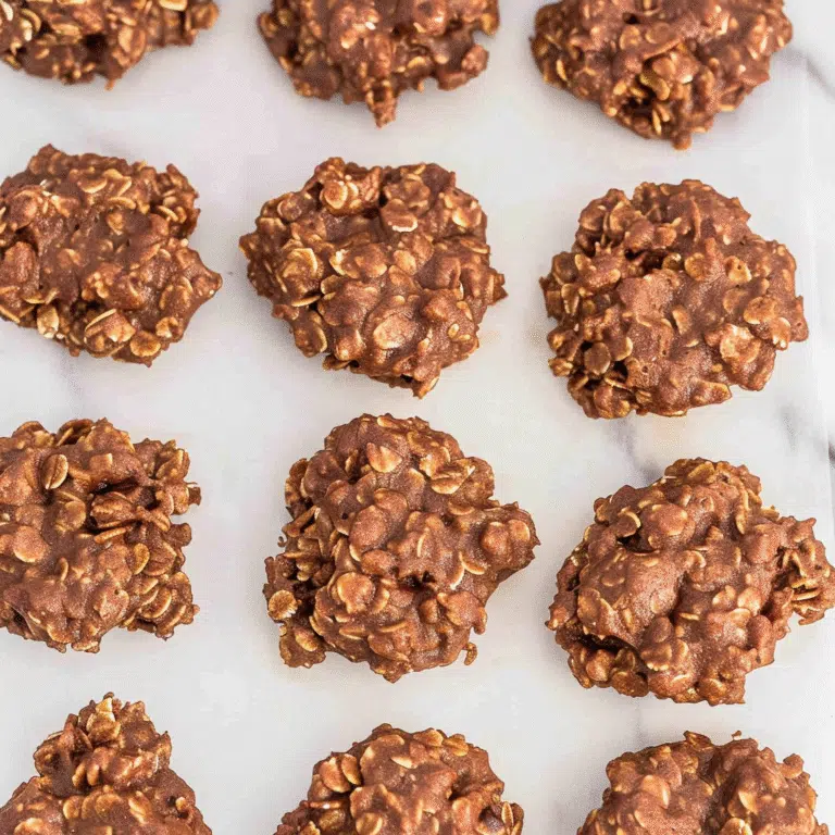 Chocolate Peanut Butter No-Bake Cookies made with oats, cocoa, and peanut butter, displayed in a top-down view on parchment paper