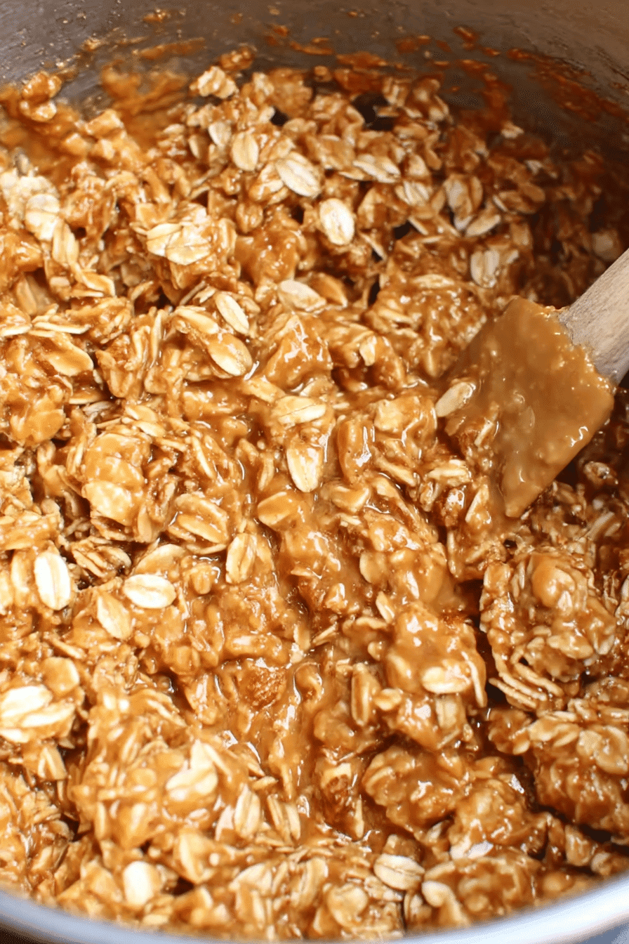 Close-up of no bake cookie mixture with oats, maple syrup, and peanut butter in a mixing bowl