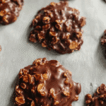 no bake oatmeal fudge drop cookies with glossy chocolate and oats on parchment paper