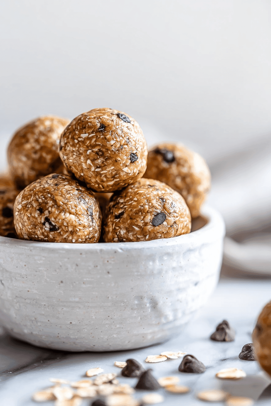 Clean-eating energy balls in a rustic ceramic bowl with oats and chocolate chips