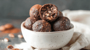 keto energy balls with chocolate and nuts in a rustic ceramic bowl.