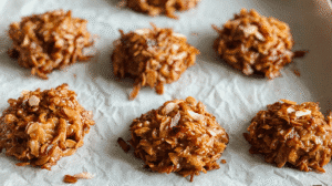Low-carb no-bake cookies with almonds and coconut cooling on parchment paper