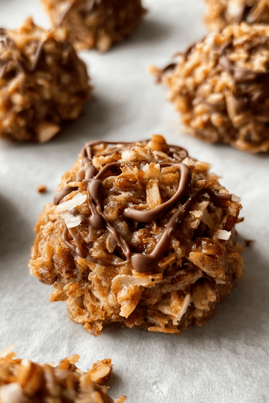 Close-up of low-carb no-bake cookie with chocolate drizzle on parchment paper.