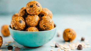 Pumpkin spice energy balls with oats and chocolate chips in a teal bowl