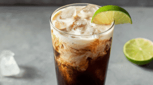 Dirty protein soda mocktail with creamy protein swirl, ice cubes, and lime garnish
