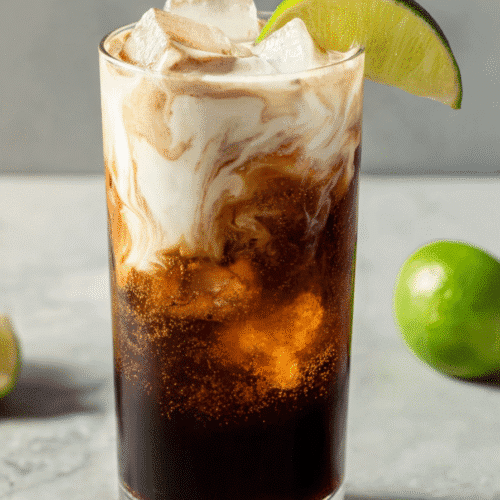 Dirty protein soda mocktail with protein swirl, ice cubes, and lime garnish