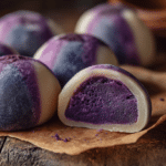 No-bake ube-stuffed mochi bites with purple filling and chewy texture on parchment paper